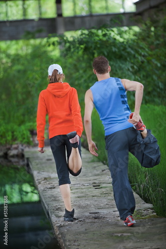 Photo: Caucasian couple warming up before running training Caucasian couple warming up before running training