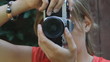 Young woman takes a photograph with 35mm film camera.
