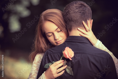 Photo: Love and affection between a young couple at the park Love and affection between a young couple at the park