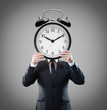 Businessman with alarm clock on head