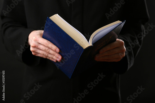 Photo: Priest reading from the holy bible, close up Priest reading from the holy bible, close up