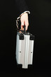 Hand with handcuff and suitcase, isolated on black