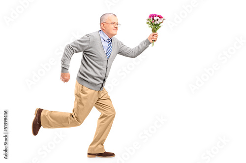 Photo: Full length portrait of a mature gentleman running with flowers Full length portrait of a mature gentleman running with flowers