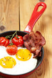 Fried eggs with bacon and tomatoes