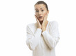 Photo: Young woman looking surprised against white background Young woman looking surprised against white background
