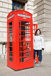 Girl close to a red english telephone-box