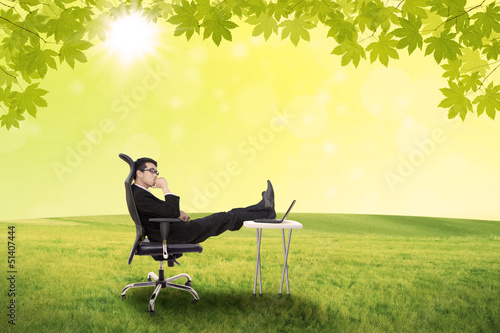 Photo: Businessman contemplating in the park Businessman contemplating in the park