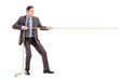 Photo: Full length portrait of a young businessman in suit pulling a ro Full length portrait of a young businessman in suit pulling a ro