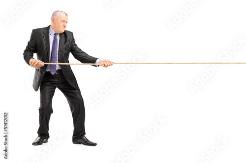 Photo: Full length portrait of a mature businessman in suit pulling a r Full length portrait of a mature businessman in suit pulling a r