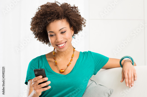Photo: Young Woman Looking At Cellphone Young Woman Looking At Cellphone