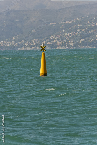 Photo: Yellow no sail metallic buoy on blue sea background Yellow no sail metallic buoy on blue sea background