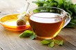 cup of tea with mint and honey on a wooden table