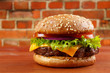 Hamburger on table with red brick wall background