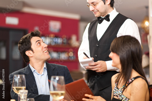 Photo: Waiter serving a couple at restaurant Waiter serving a couple at restaurant