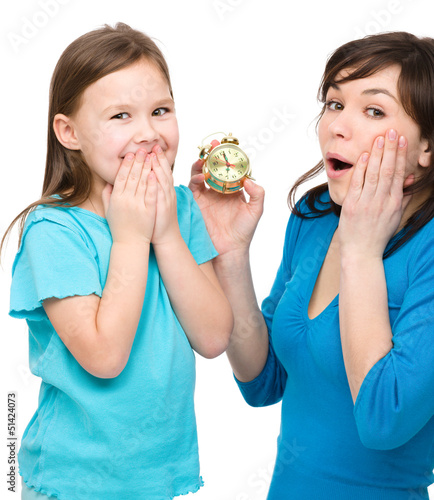 Photo: Little girl and her mother are anxious about time Little girl and her mother are anxious about time