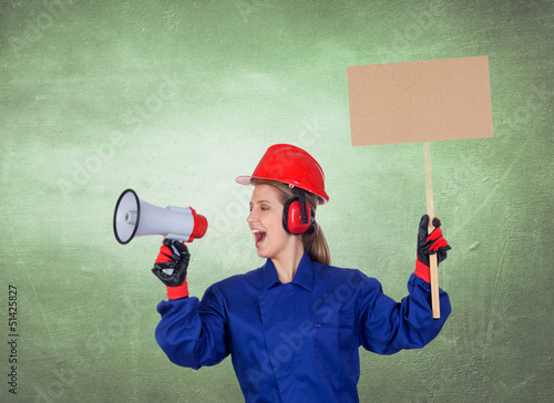 Photo: Industrial worker woman with a megaphone and a poster Industrial worker woman with a megaphone and a poster