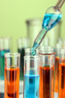Laboratory pipette with drop of color liquid over glass test