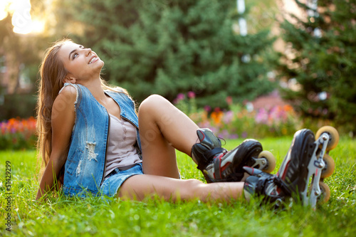 Photo: girl wearing roller skates sitting on grass girl wearing roller skates sitting on grass
