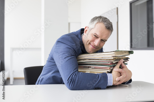 Photo: Mann mit Akten im Büro Mann mit Akten im Büro
