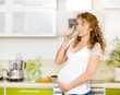 Photo : pregnant woman drink water in the kitchen pregnant woman drink water in the kitchen