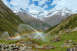 Rainbows in irrigation water spouts in Summer Alps mountain