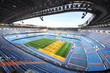 Large football stadium with  blue grandstand