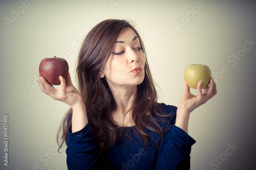 Photo: beautiful woman choosing red or yellow apples beautiful woman choosing red or yellow apples