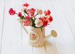 Pink and white carnation flowers in the provence watering can