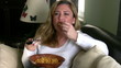 Woman watching tv and eating chips