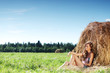 girl next to a stack of hay