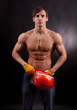 Muscular young man with an orange helmet on a black background.