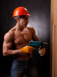 Muscular young worker with an electric drill