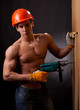 Muscular young worker with an electric drill