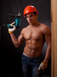 Muscular young worker with an electric drill