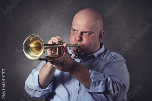 Photo: Man with strong expression plays a trumpet Man with strong expression plays a trumpet