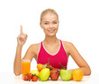 woman with juice and fruits holding finger up