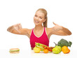 woman with fruits and hamburger comparing food