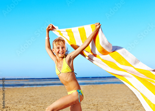 Photo: Child running at beach with towel. Child running at beach with towel.
