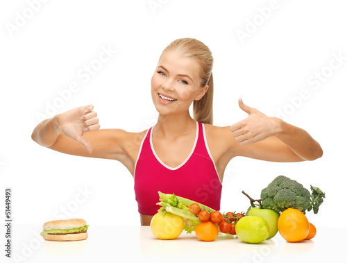 Photo: woman with fruits and hamburger comparing food woman with fruits and hamburger comparing food