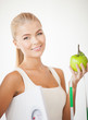 sporty woman with scale, apple and measuring tape