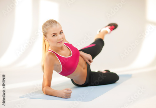 Photo: sporty woman doing exercise on the floor sporty woman doing exercise on the floor