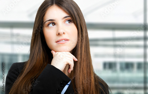 Photo: Young businesswoman thinking smiling looking up Young businesswoman thinking smiling looking up