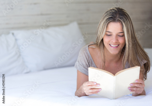 Photo: Woman reading in bed Woman reading in bed