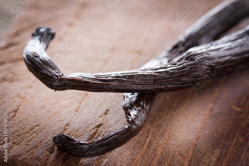Photo: Black vanilla sticks on wooden table Black vanilla sticks on wooden table