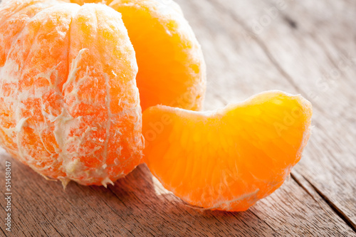 Photo: Peeled tangerine on wooden table Peeled tangerine on wooden table