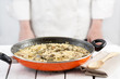 Cook standing behind a pan on vegetables rice