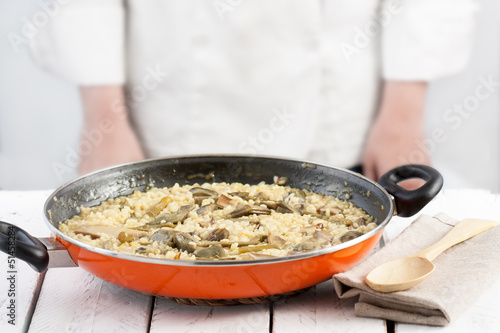 Photo: Cook standing behind a pan on vegetables rice Cook standing behind a pan on vegetables rice