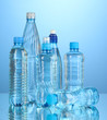 Photo: Different water bottles on blue background Different water bottles on blue background