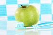 Apple with a toothbrush on shelf in bathroom