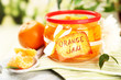 Orange jam with zest and tangerines, on white wooden table
